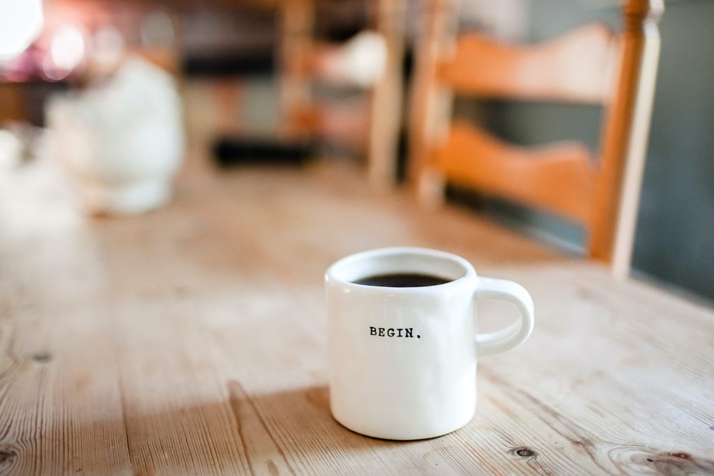 Unsplash photo by Danielle MacInnes, "Begin" - white ceramic mug. Photo to encourage others to begin to lead well.