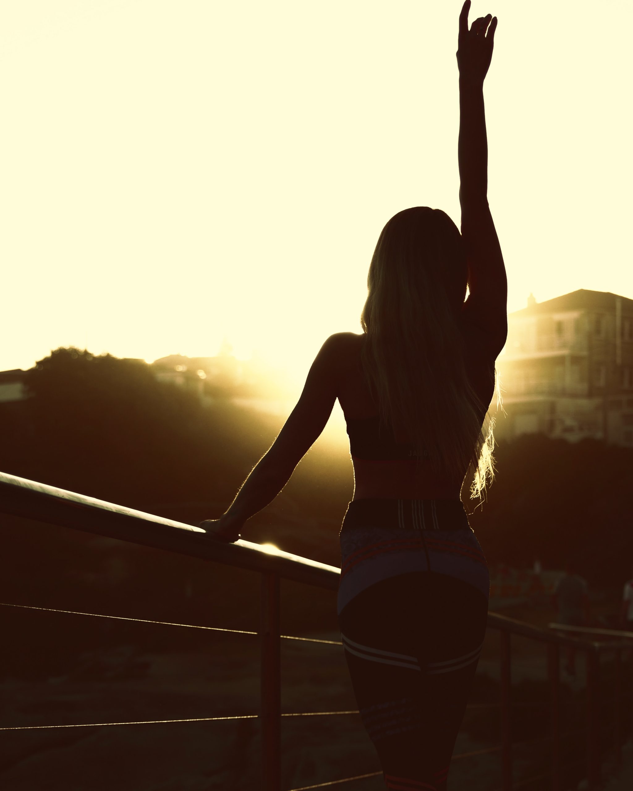 Unsplash photo by Nathaniel Vala - woman in tank top and black shorts standing on balcony during sunset - physical stamina to journey through hard things
