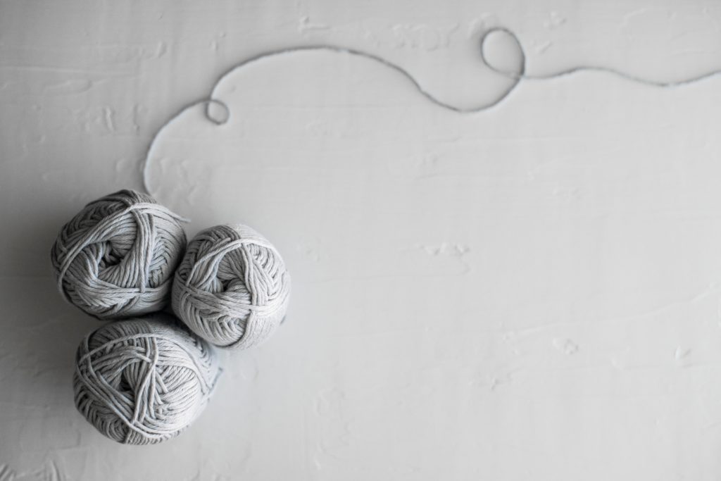 Unsplash photo by Tara Evans - the unraveling of grief - flat lay photography of three white yarn balls